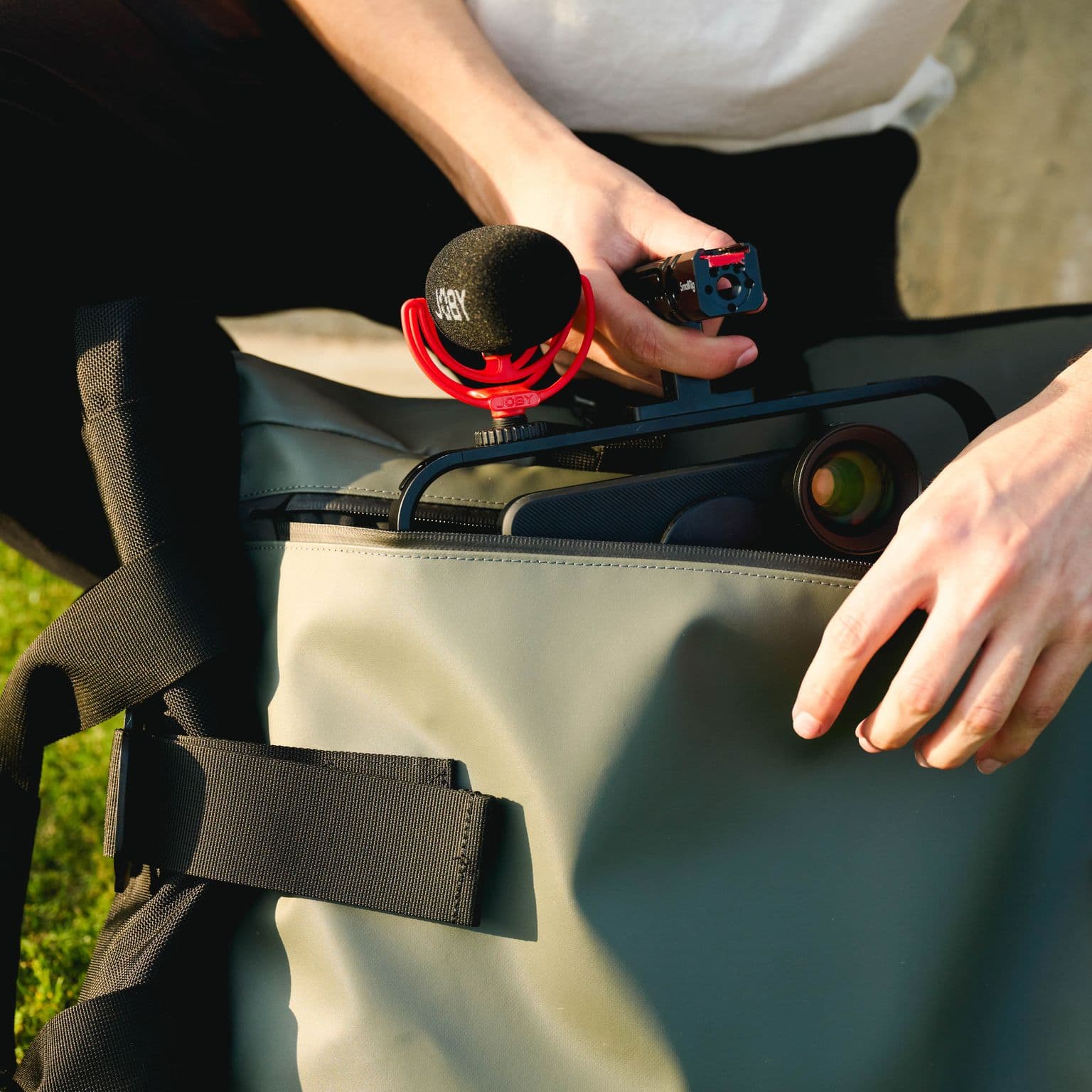 Placing iPhone into WANDRD backpack with a JOBY mic.